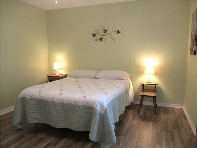 bedroom featuring wood finished floors and baseboards