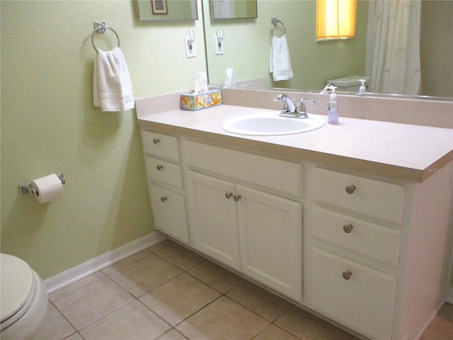 bathroom with tile patterned flooring, toilet, baseboards, and vanity