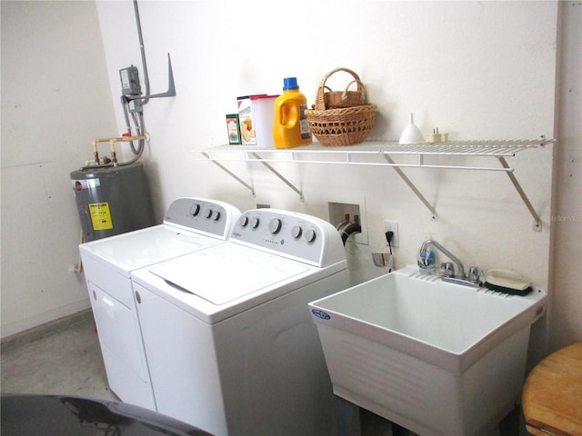 clothes washing area with a sink, water heater, laundry area, washing machine and dryer, and baseboards