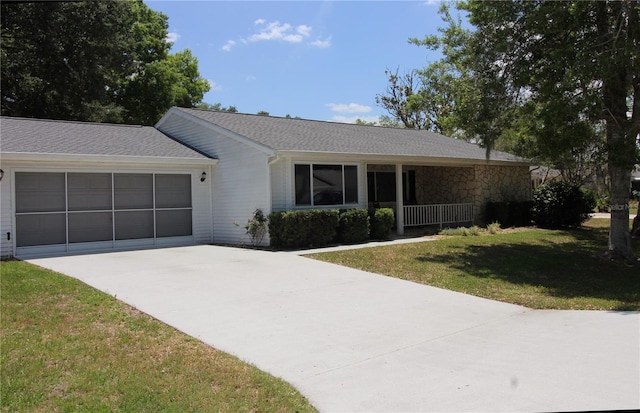 ranch-style house with concrete driveway, an attached garage, and a front lawn
