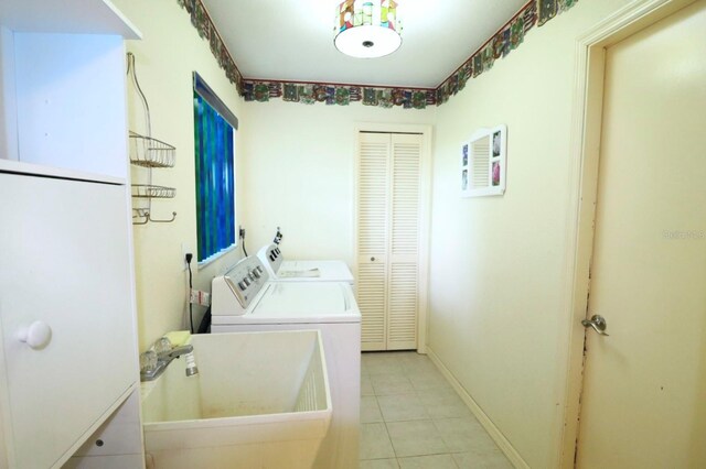 5351 SW 80th Pl, Ocala, FL 34476 - laundry area featuring washing machine and clothes dryer, light tile patterned flooring, and baseboards