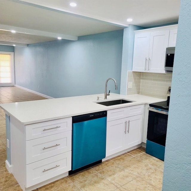 kitchen with stainless steel appliances, a sink, a peninsula, light countertops, and recessed lighting
