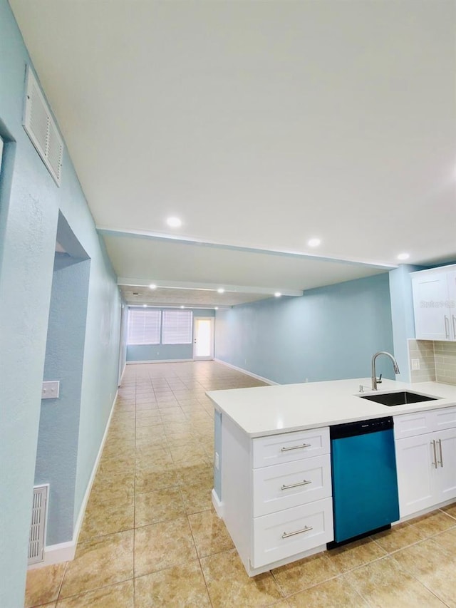kitchen with a sink, dishwasher, white cabinets, light countertops, and a peninsula