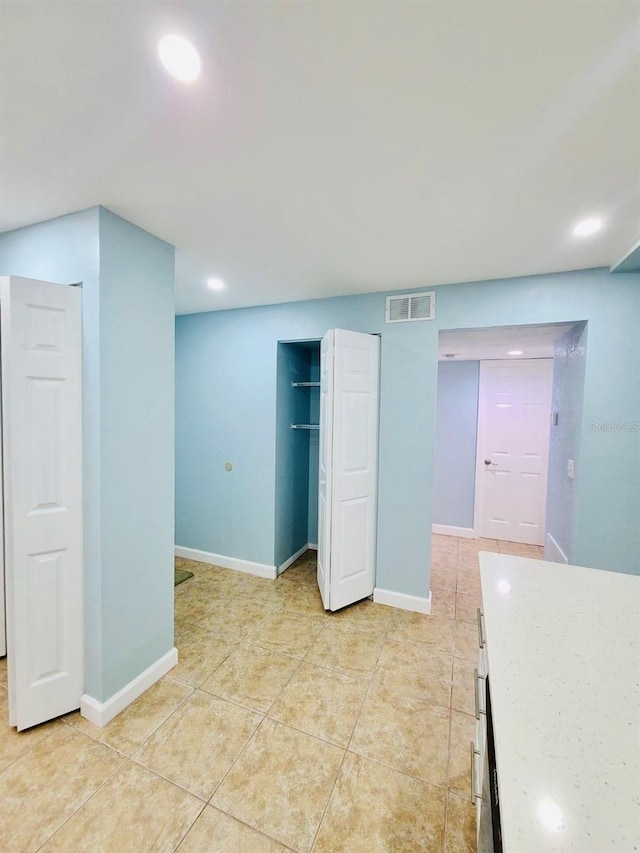 basement featuring recessed lighting, light tile patterned flooring, and baseboards