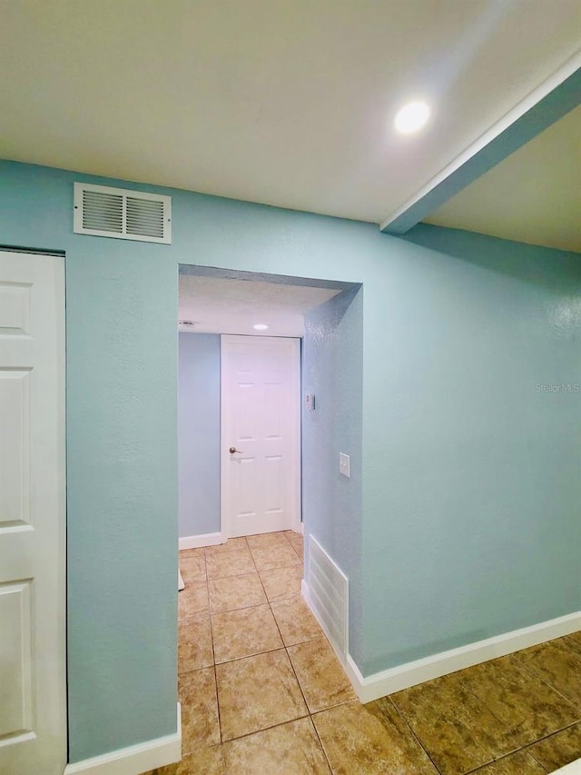 corridor featuring light tile patterned floors, baseboards, and recessed lighting