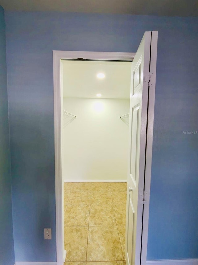 hallway with tile patterned floors, recessed lighting, and baseboards