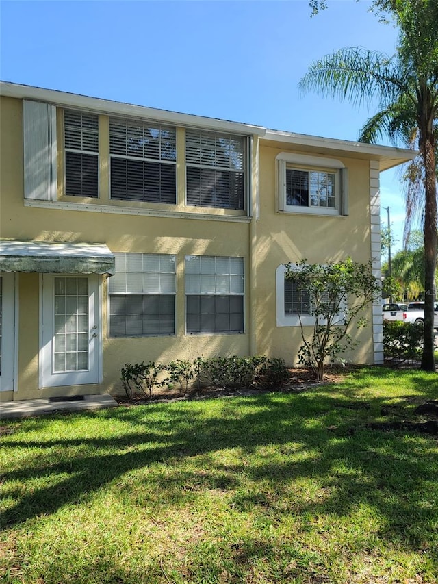 view of home's exterior featuring stucco siding and a lawn