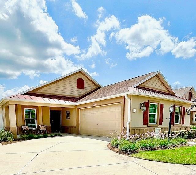 3023 Charlevoix St, The Villages, FL 32163 - view of front facade with an attached garage, driveway, covered porch, and stucco siding