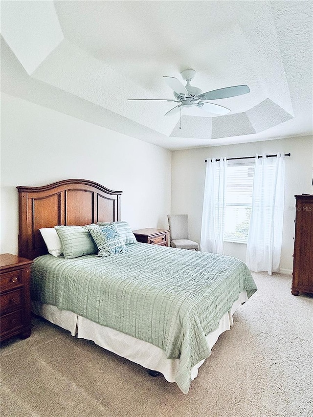 3023 Charlevoix St, The Villages, FL 32163 - bedroom featuring light colored carpet, a textured ceiling, a tray ceiling, and ceiling fan