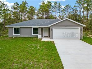 23163 NW Shamrock Ave, Dunnellon, FL 34431 - single story home with an attached garage, driveway, and a front lawn