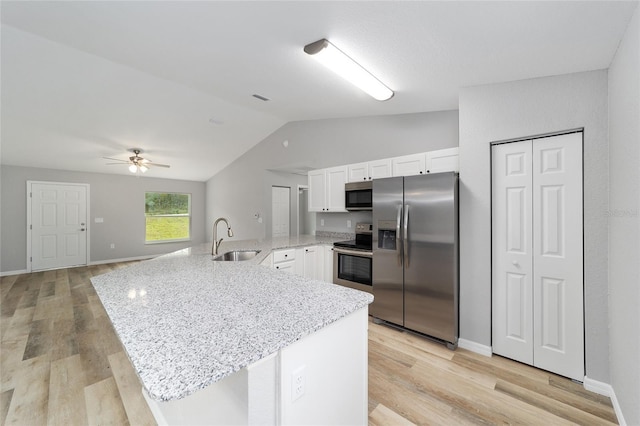 23163 NW Shamrock Ave, Dunnellon, FL 34431 - kitchen featuring appliances with stainless steel finishes, lofted ceiling, a sink, a peninsula, and white cabinets