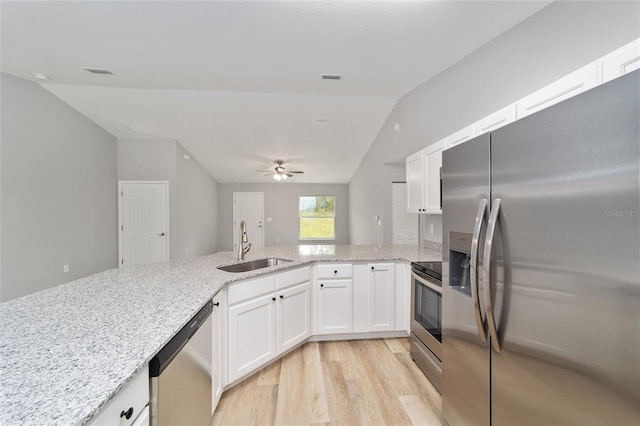 23163 NW Shamrock Ave, Dunnellon, FL 34431 - kitchen with appliances with stainless steel finishes, lofted ceiling, a sink, light wood finished floors, and light stone countertops