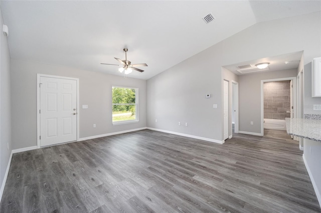 23163 NW Shamrock Ave, Dunnellon, FL 34431 - unfurnished living room featuring lofted ceiling, wood finished floors, ceiling fan, and baseboards