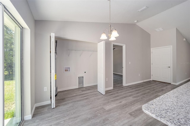23163 NW Shamrock Ave, Dunnellon, FL 34431 - unfurnished dining area featuring a chandelier, vaulted ceiling, light wood-style flooring, and baseboards