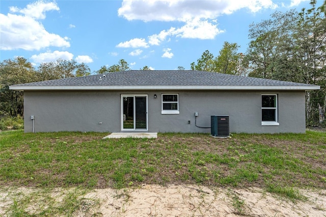 23163 NW Shamrock Ave, Dunnellon, FL 34431 - rear view of property featuring stucco siding, central AC, and a yard