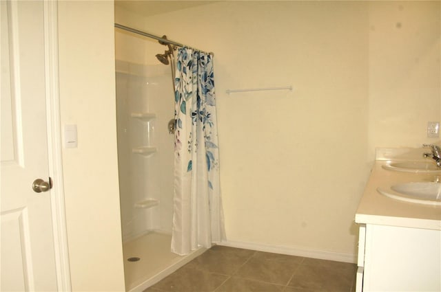 full bath with tile patterned floors, a shower with curtain, double vanity, and baseboards