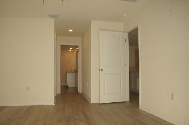 empty room with baseboards, wood finished floors, and recessed lighting