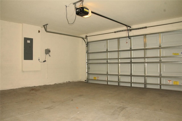 garage with a garage door opener, electric panel, and concrete block wall