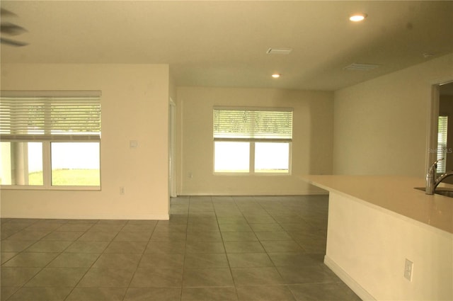 spare room featuring dark tile patterned flooring, recessed lighting, and baseboards