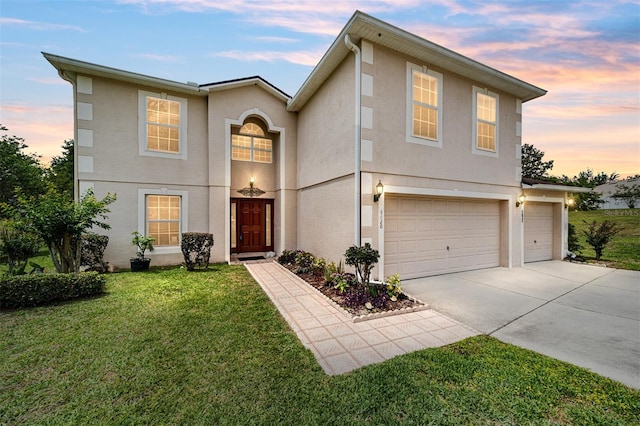 view of front of property featuring stucco siding, an attached garage, concrete driveway, and a front lawn
