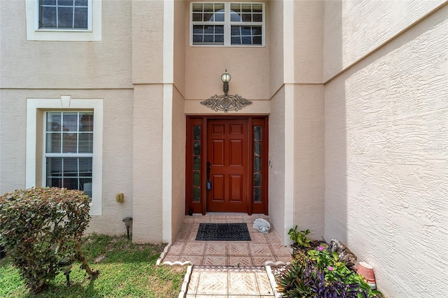 entrance to property featuring stucco siding