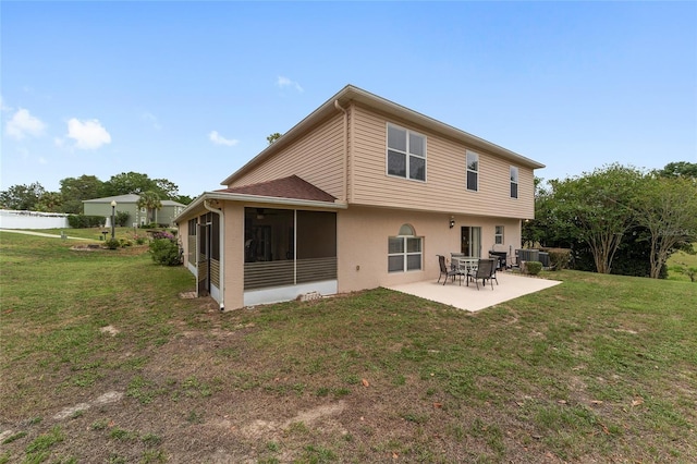 rear view of property with a patio area, a lawn, a sunroom, and stucco siding