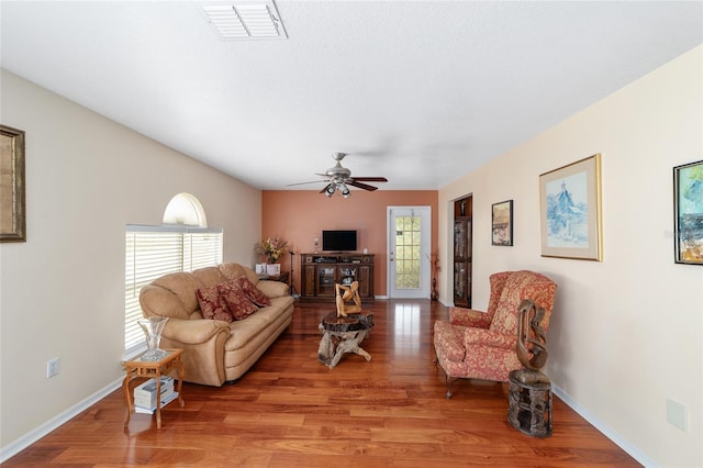 living room featuring light wood-style floors, a ceiling fan, and baseboards