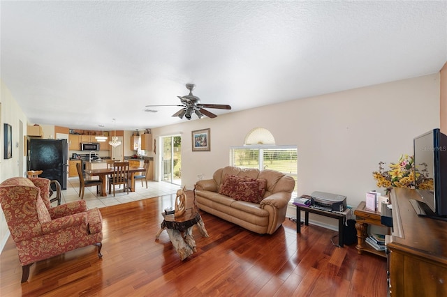 living room featuring light wood finished floors and a ceiling fan