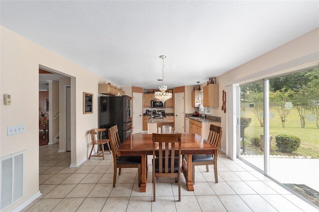 dining space with a chandelier, light tile patterned floors, and baseboards