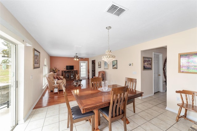 dining room featuring a chandelier, light tile patterned flooring, a ceiling fan, and baseboards