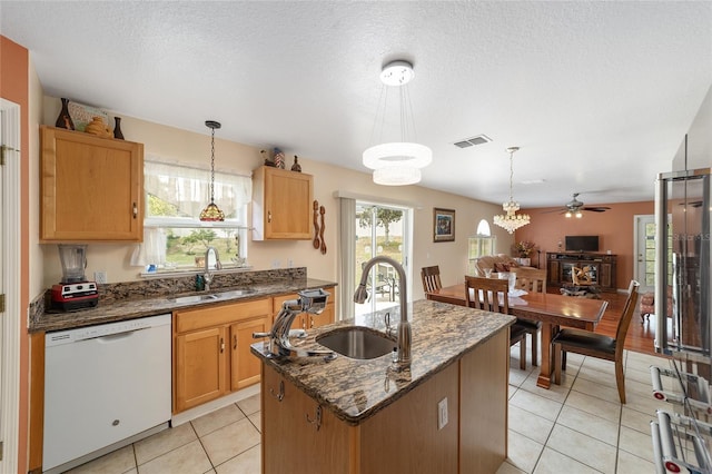 kitchen featuring dishwasher, a sink, a ceiling fan, decorative light fixtures, and a textured ceiling