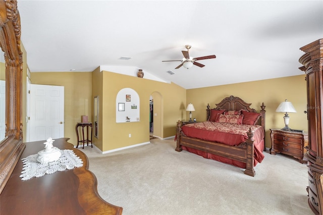 carpeted bedroom featuring arched walkways, lofted ceiling, baseboards, and ceiling fan