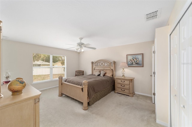 bedroom with light colored carpet, baseboards, a closet, and ceiling fan