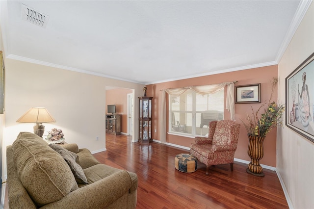 living room with wood finished floors, ornamental molding, and baseboards