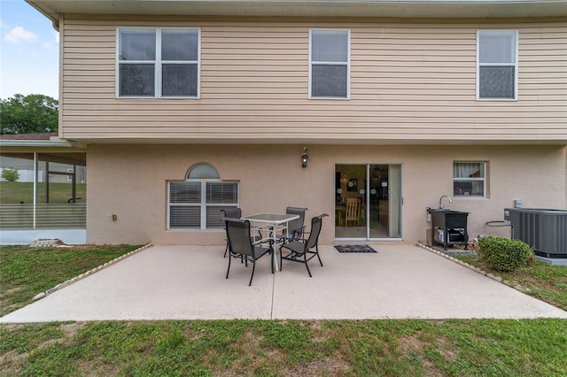 rear view of house featuring cooling unit, a patio, and stucco siding