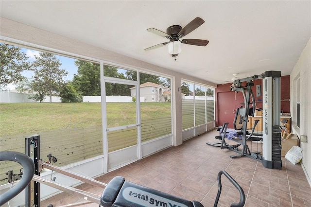 exercise room with ceiling fan and tile patterned floors