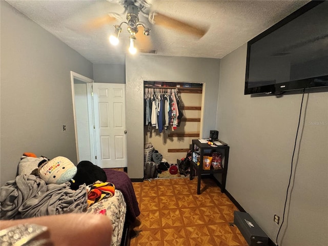 bedroom with a closet, a textured ceiling, and ceiling fan