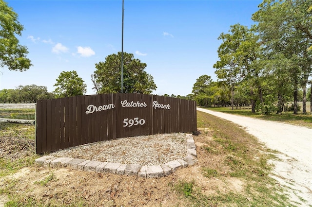 community / neighborhood sign featuring fence