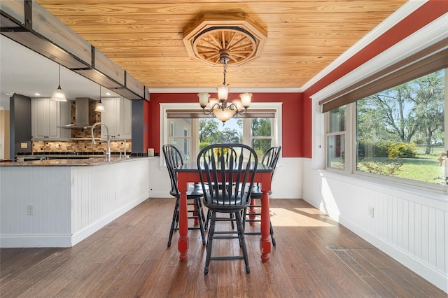 dining area featuring a chandelier, wood ceiling, wood-type flooring, baseboards, and crown molding