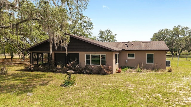 rear view of house featuring central AC and stucco siding