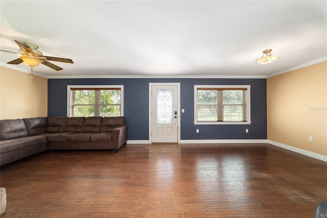 unfurnished living room featuring ornamental molding, hardwood / wood-style floors, ceiling fan, and baseboards