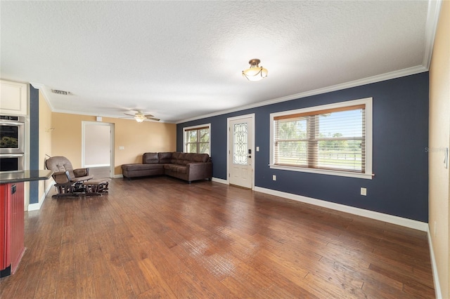 living area with ornamental molding, dark wood-type flooring, a textured ceiling, baseboards, and ceiling fan