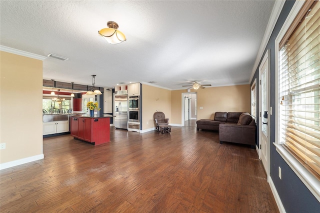 living area featuring ceiling fan, dark wood-type flooring, ornamental molding, baseboards, and a textured ceiling