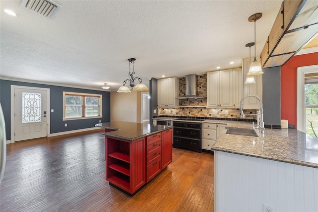 kitchen featuring open shelves, wall chimney exhaust hood, a sink, dark wood-style floors, and a textured ceiling