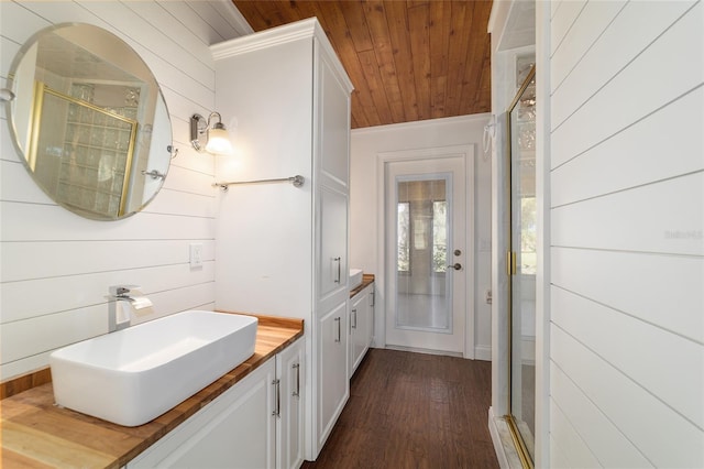 bathroom featuring wooden ceiling, a shower stall, wood finished floors, vanity, and wood walls