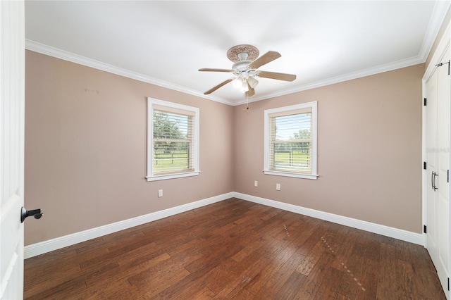 empty room featuring wood finished floors, baseboards, ornamental molding, and a ceiling fan