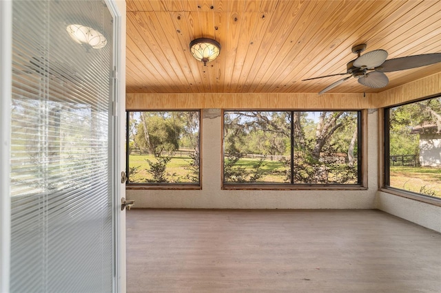 unfurnished sunroom with wood ceiling and wood finished floors