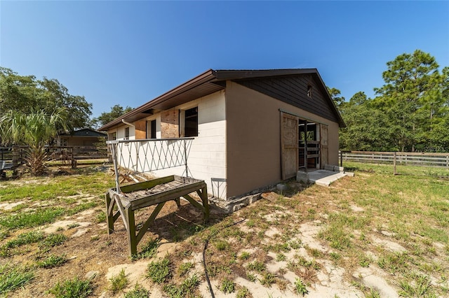 view of home's exterior with concrete block siding and fence