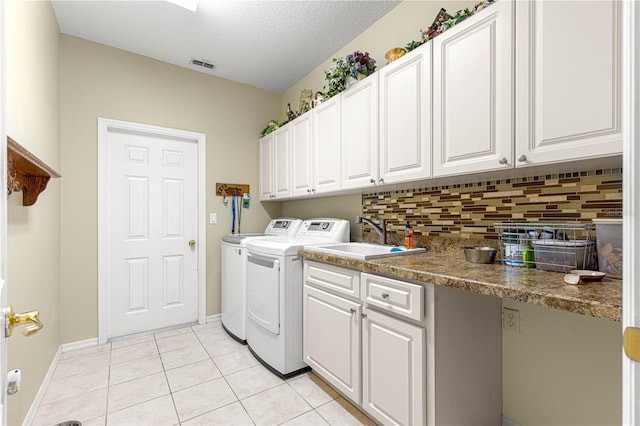13885 Del Webb Blvd, Summerfield, FL 34491 - laundry room with separate washer and dryer, light tile patterned flooring, baseboards, a textured ceiling, and cabinet space