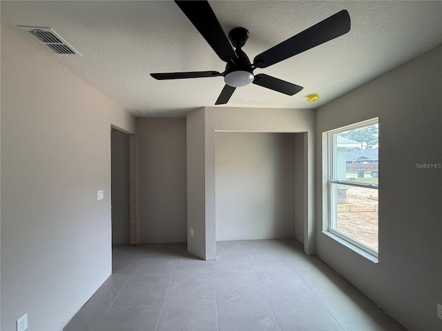 5359 NW 55th Pl, Ocala, FL 34482 - empty room featuring a textured ceiling, a ceiling fan, and light tile patterned floors